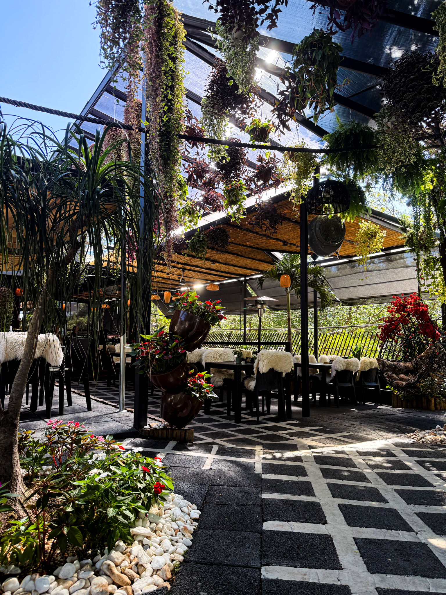 Ambiente externo do Garden Café com mesas no jardim